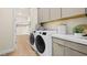 Bright laundry room with modern washer, dryer, and storage cabinets near walk-in closet at 243 Paraggi Bay Dr, Henderson, NV 89011