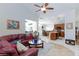 Inviting living room and kitchen area features a leather sofa, ceiling fan, and modern appliances at 270 New River Cir, Henderson, NV 89052