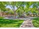 A well-maintained playground area with green grass and mature shade trees at 270 New River Cir, Henderson, NV 89052