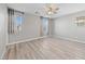 This bright bedroom features hardwood floors, a ceiling fan, and multiple windows at 2785 Donatello Manor Pl, Henderson, NV 89044
