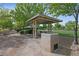 Inviting picnic area with a covered table and a BBQ, ideal for outdoor gatherings in a green park setting at 2785 Donatello Manor Pl, Henderson, NV 89044
