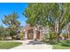 Beautiful two-story home with a brick facade, manicured landscaping, and a circular driveway at 3102 La Mirada Ave, Las Vegas, NV 89120