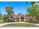 Stunning two-story brick home with a well-manicured lawn and mature trees on a sunny day at 3102 La Mirada Ave, Las Vegas, NV 89120