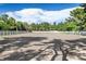 A large sand horse arena with white fencing is surrounded by mature trees and blue skies at 3102 La Mirada Ave, Las Vegas, NV 89120