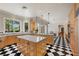 Bright kitchen with granite countertops, double islands, and black and white checkered floors at 3102 La Mirada Ave, Las Vegas, NV 89120