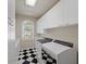 Laundry room featuring sleek appliances, white cabinets, and a black and white checkered floor at 3102 La Mirada Ave, Las Vegas, NV 89120