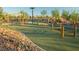 Community playground with climbing structures, swings and a soft turf surface at 340 N Taylor St, Henderson, NV 89015