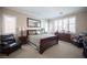 Spacious bedroom with neutral colored walls, large window, bed and seating at 3468 Isle Dr, Las Vegas, NV 89141