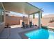Outdoor space featuring a covered patio with seating area and view of the sparkling pool with rock waterfall at 3468 Isle Dr, Las Vegas, NV 89141
