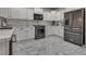 Modern kitchen featuring white cabinets, black stainless steel appliances, and a stylish backsplash at 4204 Sprints Race Ave, North Las Vegas, NV 89084