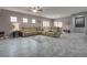 Spacious living room featuring a large leather sectional and stylish gray tile flooring at 4204 Sprints Race Ave, North Las Vegas, NV 89084