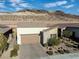 Aerial view of a desert home with desert landscaping, brick driveway, and a mountain in the background at 44 Alta Cascata Pl, Henderson, NV 89011