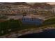 Scenic aerial view of a golf course community with a large pond and mountain backdrop at 44 Alta Cascata Pl, Henderson, NV 89011