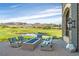 A luxury patio with a fire pit and comfortable seating, overlooking a golf course and distant mountains at 44 Alta Cascata Pl, Henderson, NV 89011