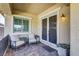 Inviting front porch with decorative doors, patio seating, and views of the landscaped yard at 480 Heritage Bridge Ave, Henderson, NV 89011