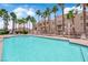 Community pool surrounded by lounge chairs and palm trees, offering a refreshing outdoor retreat at 5000 Red Rock St # 259, Las Vegas, NV 89118
