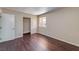 Bright bedroom featuring wood-look floors, a closet, and a sunlit window overlooking the neighborhood at 5021 River Glen Dr # 45, Las Vegas, NV 89103