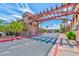 Community entrance with a decorative wooden pergola structure surrounded by lush landscaping at 5021 River Glen Dr # 45, Las Vegas, NV 89103