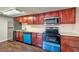Well-lit kitchen featuring cherry wood cabinets, stainless steel appliances, and white countertops at 5021 River Glen Dr # 45, Las Vegas, NV 89103