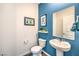 Stylish half bathroom featuring blue walls, a pedestal sink, decorative mirror, and modern accents at 516 Red Lovebird Ave # Lot 1242, Henderson, NV 89011