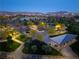 Dusk aerial shot of a community park featuring playground, picnic area, and walking paths amidst trees and landscaping at 516 Red Lovebird Ave # Lot 1242, Henderson, NV 89011