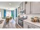 Modern kitchen design with sleek gray cabinets, stainless steel appliances, quartz countertops, and a dining area at 516 Red Lovebird Ave # Lot 1242, Henderson, NV 89011