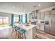 Bright kitchen featuring gray cabinets, stainless steel appliances, island with seating, and an adjacent dining area at 516 Red Lovebird Ave # Lot 1242, Henderson, NV 89011