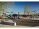 Community playground featuring play structure, swings, with a bench for parents to relax at 516 Red Lovebird Ave # Lot 1242, Henderson, NV 89011