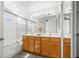Bright bathroom featuring double sinks, wooden cabinets, large mirror and shower with glass doors at 5201 S Torrey Pines Dr # 1221, Las Vegas, NV 89118