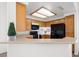 Kitchen featuring warm wood cabinetry and modern appliances with a countertop overlooking the living space at 5201 S Torrey Pines Dr # 1221, Las Vegas, NV 89118