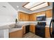 Kitchen features wood cabinets, black appliances, and light countertops at 5201 S Torrey Pines Dr # 1221, Las Vegas, NV 89118