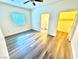 Bright bedroom with modern wood-look flooring and a ceiling fan, leading to the bathroom and a closet at 5250 S Rainbow Blvd # 2029, Las Vegas, NV 89118