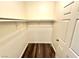 Walk-in closet with hanging rod and shelf, featuring wood-look flooring and a neutral color at 5250 S Rainbow Blvd # 2029, Las Vegas, NV 89118