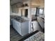 Open-concept kitchen and living room with elegant gray cabinetry and a cozy sofa at 5335 Rod Ct # 102, Las Vegas, NV 89122