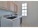 Well-lit laundry room features Samsung washer/dryer set, tiled floor, and overhead cabinets at 5341 Cool Dawn Ct, Las Vegas, NV 89130