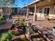 Backyard patio with dining furniture, garden bed full of potted colorful plants and shrubs and detached structure at 603 Palmhurst Dr, Las Vegas, NV 89145