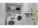 Modern laundry room with front loading washer/dryer and efficient water heater at 603 Palmhurst Dr, Las Vegas, NV 89145