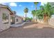 Backyard featuring rock landscaping and a splash pool, bordered by mature palm trees, creating a serene retreat at 6231 Curlew Dr, Las Vegas, NV 89122