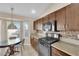 Kitchen featuring dark cabinetry, tile backsplash, stainless steel appliances, and tile floors at 6231 Curlew Dr, Las Vegas, NV 89122