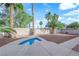 Backyard with a small splash pool, surrounded by palm trees and rock landscaping, perfect for relaxing at 6231 Curlew Dr, Las Vegas, NV 89122