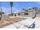 The backyard of this white home has a dirt area ready for landscaping and a large concrete patio at 6305 Fairwood Ave, Las Vegas, NV 89107