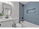 Modern bathroom featuring a bathtub-shower combo with blue vertical tiles, and sleek black fixtures at 6305 Fairwood Ave, Las Vegas, NV 89107