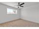 Bright and airy bedroom featuring neutral carpet, a ceiling fan, and a large window with natural light at 6305 Fairwood Ave, Las Vegas, NV 89107