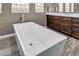 Modern bathroom featuring a soaking tub, wood-look tile floors, and stylish dark wood vanity at 6423 Grayback Dr, North Las Vegas, NV 89084