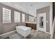 Bright bathroom features a modern tub, wood look floors, and multiple glass block windows at 6423 Grayback Dr, North Las Vegas, NV 89084