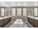 Elegant bathroom showcasing dual vanities, a soaking tub, and three glass block windows at 6423 Grayback Dr, North Las Vegas, NV 89084