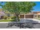 Beautiful single-story home with a well-manicured lawn and a two-car garage, shaded by a large tree at 6423 Grayback Dr, North Las Vegas, NV 89084
