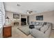 Cozy living room with a fireplace, ceiling fan, and a comfortable sectional sofa at 6423 Grayback Dr, North Las Vegas, NV 89084