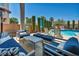 Stylish patio featuring comfortable seating, a dining area, and serene views of the well-manicured backyard and pool at 6423 Grayback Dr, North Las Vegas, NV 89084