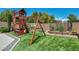 Playground with playhouse, swing set, and artificial turf at 6423 Grayback Dr, North Las Vegas, NV 89084